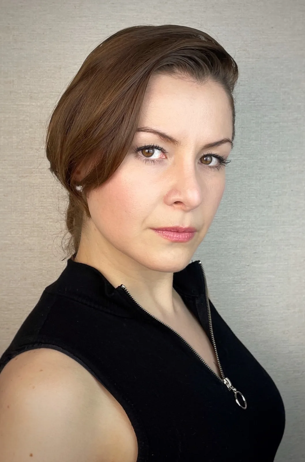 Wendy Lechuga theatrical headshot — black zip top, sleek hair, dramatic editorial side light