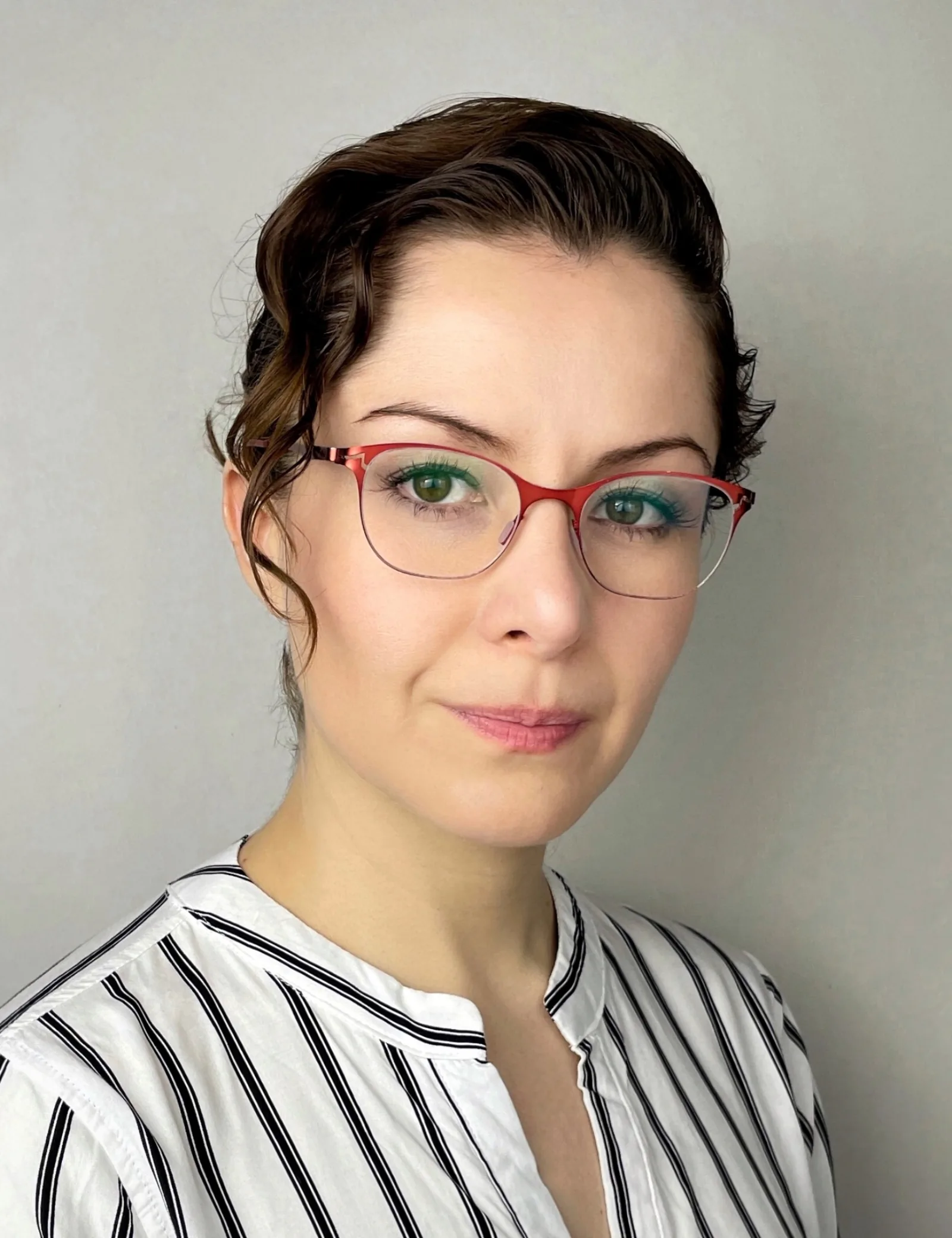 Wendy Lechuga in white striped shirt with red glasses — quirky, character / comedic headshot