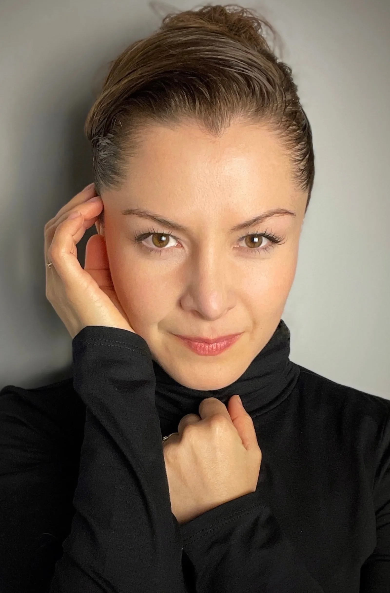 Wendy Lechuga in black turtleneck with hand to face — soft, intimate cinematic portrait