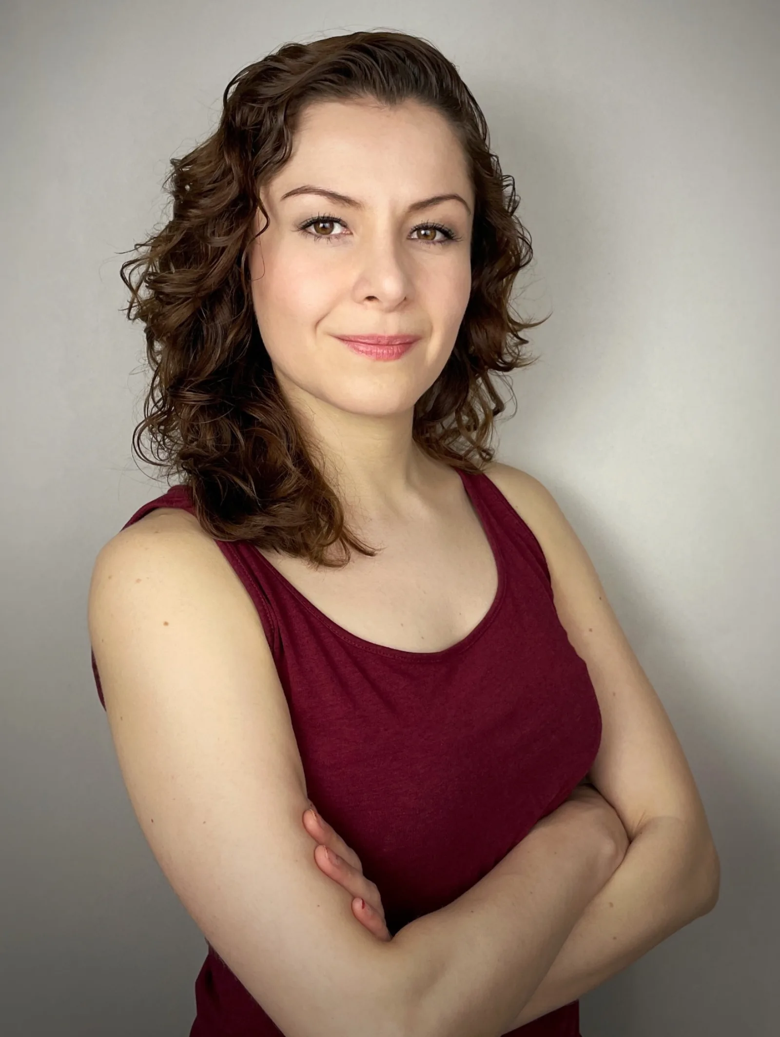 Wendy Lechuga in burgundy tank top with arms crossed — friendly, confident lifestyle headshot