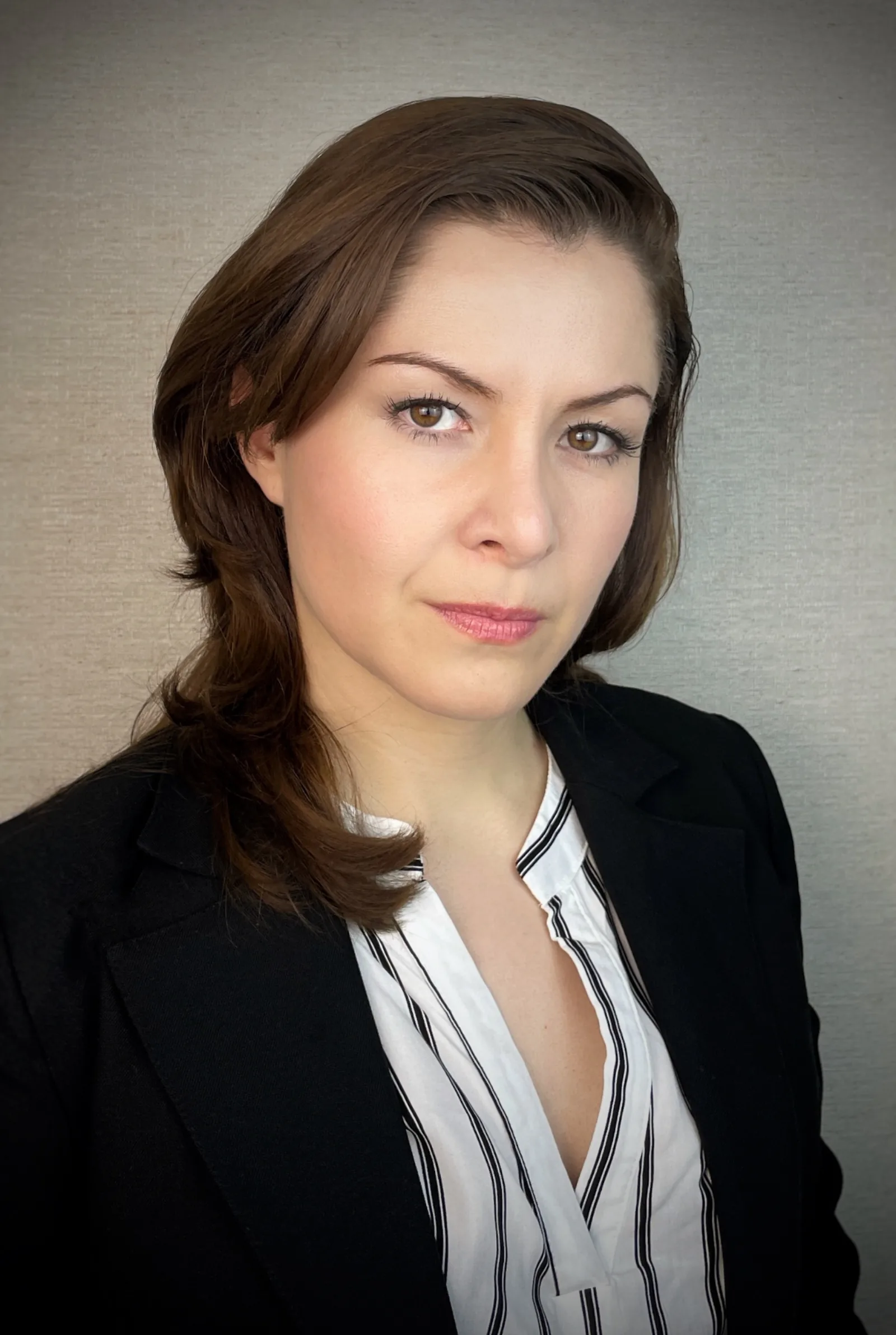 Wendy Lechuga editorial headshot in black blazer and striped blouse — confident, cinematic side light